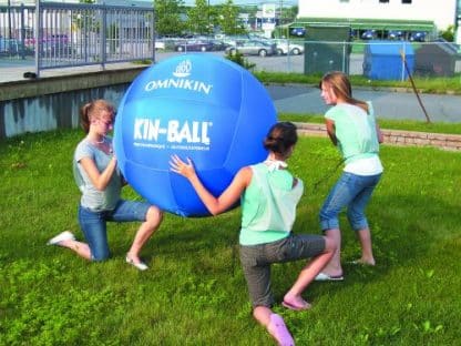 ballon de kin ball bleu géant et personnes jouent dans l'herbe