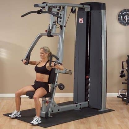 machine de musculation femme blonde assise et fait des exercices de bras