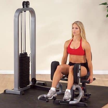 machine de musculation femme assise dessus, blonde, baskets, brassière rouge