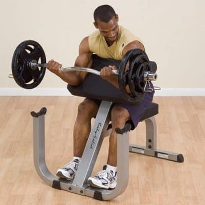 machine de musculation noire et grise homme en débardeur jaune muscle les bras