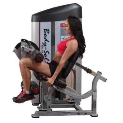 machine de musculation sur fond blanc femme brune brassière rouge exercice musculation