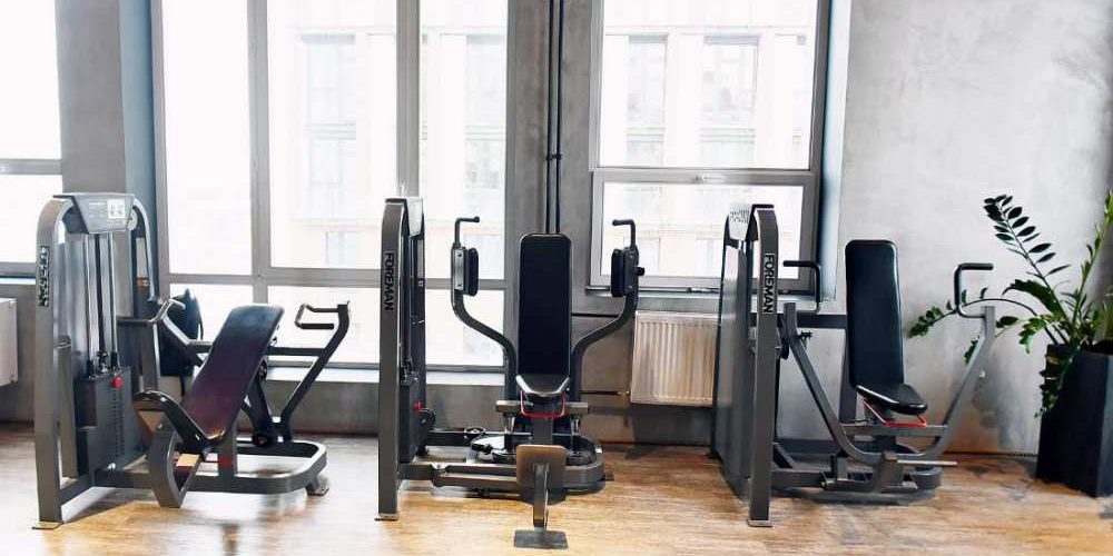salle de sport avec trois machines de musculation