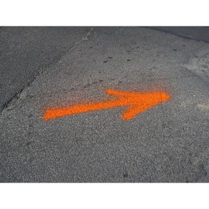 Marquage fluorescent orange d'une flèche sur une route