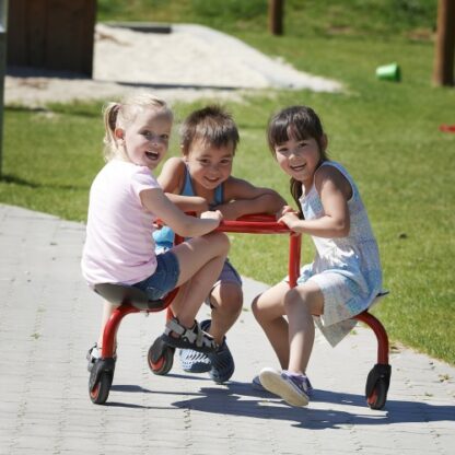 3 enfants sur le jeu pour enfant circlebike viking de couleur rouge avec 3 sièges et sur roulettes
