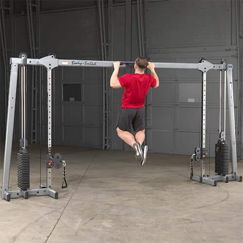 machine de musculation homme en t-shirt rouge tractions