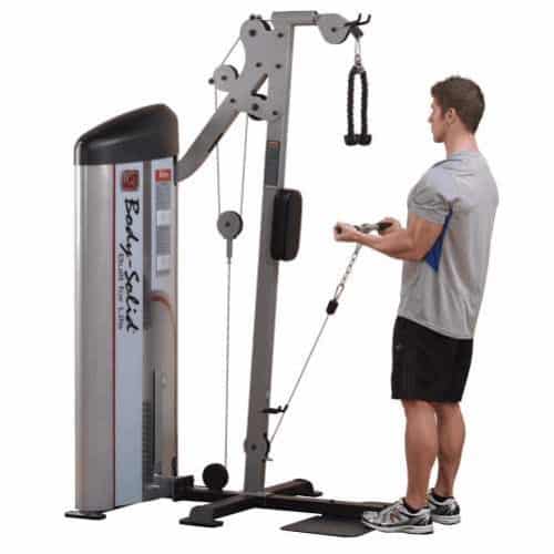 machine de musculation homme debout en t-shirt gris et bleu