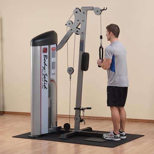 machine de musculation homme debout en gris se muscle les bras