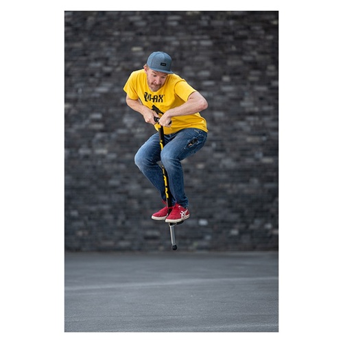 Adulte rebondissant avec un bâton sauteur Pogo Stick de couleur noire